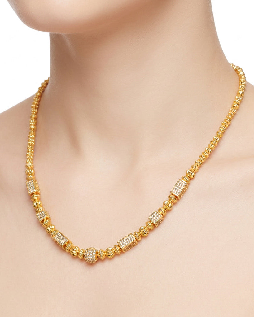 Gold necklace with diamond accents on a white background